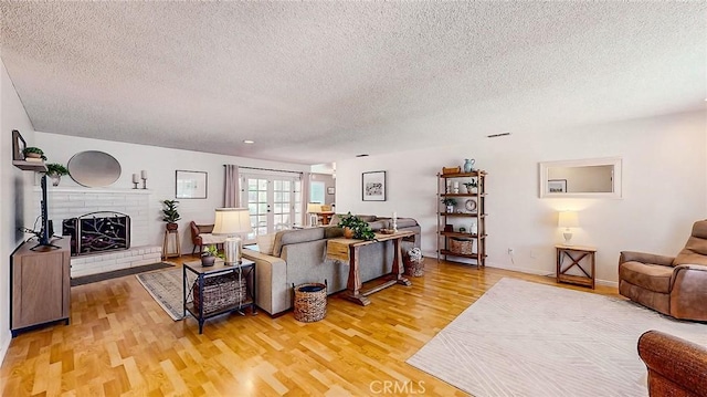 3360 Vanderbilt Ave, Turlock, CA 95382 - living room with a textured ceiling, light wood-type flooring, and a brick fireplace