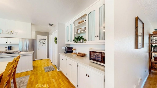 3360 Vanderbilt Ave, Turlock, CA 95382 - kitchen featuring stainless steel appliances, light wood finished floors, white cabinetry, light countertops, and open shelves