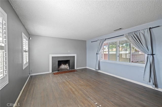 1906 Cloverdale Dr, Pomona, CA 91767 - unfurnished living room with wood finished floors, a textured ceiling, and a fireplace with flush hearth