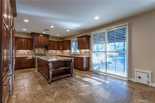 35467 Meadow Park Cir, Wildomar, CA 92595 - kitchen with open shelves, stainless steel stove, decorative backsplash, a center island, and stone tile floors