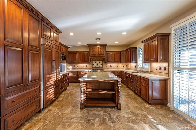 35467 Meadow Park Cir, Wildomar, CA 92595 - kitchen featuring built in appliances, backsplash, light stone countertops, a center island, and recessed lighting
