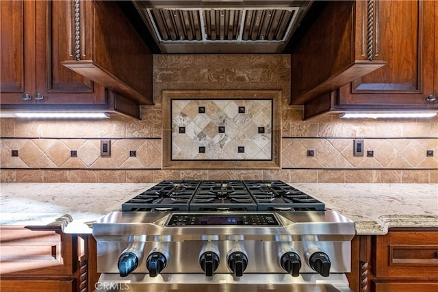 35467 Meadow Park Cir, Wildomar, CA 92595 - kitchen with exhaust hood, light stone countertops, stove, decorative backsplash, and brown cabinets