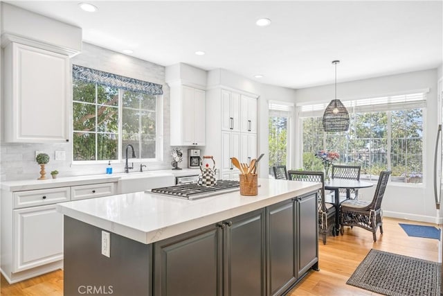 22681 Maplewood, Mission Viejo, CA 92692 - kitchen with white cabinetry, light countertops, stainless steel gas stovetop, a center island, and hanging light fixtures