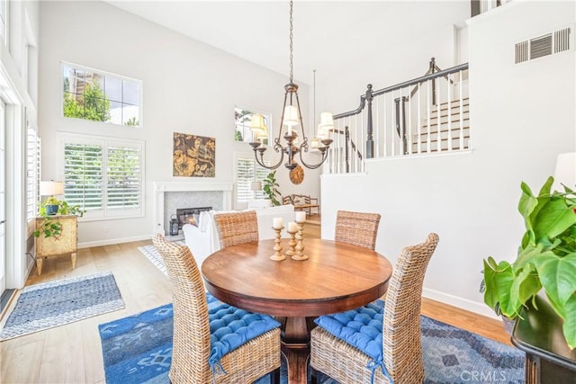 22681 Maplewood, Mission Viejo, CA 92692 - dining area with wood finished floors, a chandelier, a high ceiling, a glass covered fireplace, and stairs