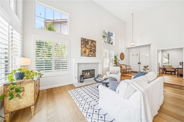 22681 Maplewood, Mission Viejo, CA 92692 - living room featuring a towering ceiling, a glass covered fireplace, and light wood-style flooring