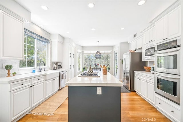 22681 Maplewood, Mission Viejo, CA 92692 - kitchen with appliances with stainless steel finishes, white cabinetry, a center island, light wood-type flooring, and recessed lighting