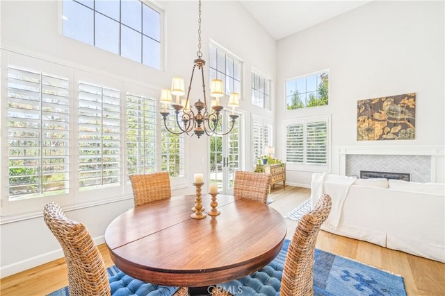22681 Maplewood, Mission Viejo, CA 92692 - dining space featuring a chandelier, wood finished floors, a high ceiling, and a fireplace