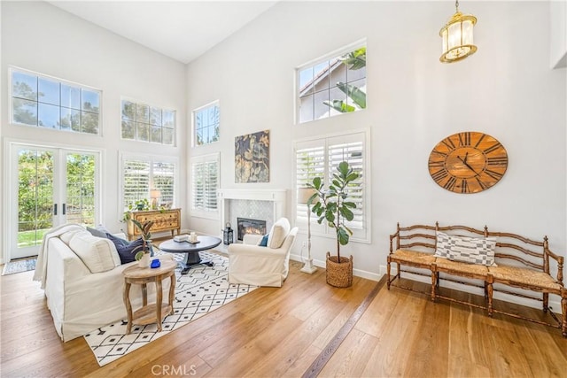22681 Maplewood, Mission Viejo, CA 92692 - living area featuring hardwood / wood-style flooring, a glass covered fireplace, and a towering ceiling