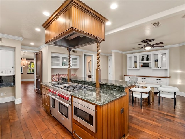 6550 N Blackhawk Ln, Clovis, CA 93619 - kitchen with stainless steel appliances, dark wood-style flooring, ornamental molding, glass insert cabinets, and a chandelier