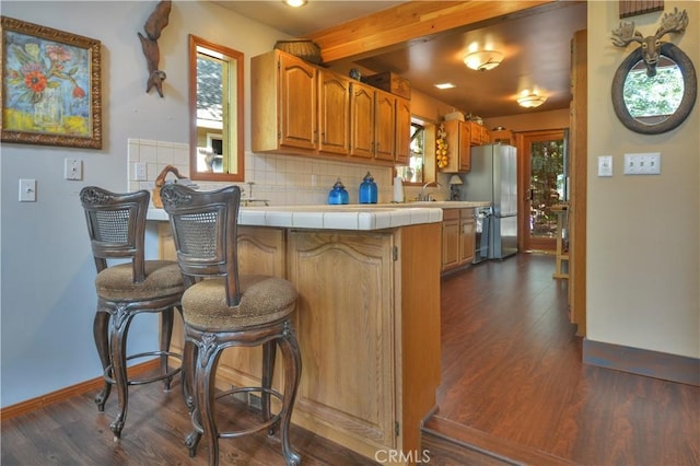 26873 Huron Rd, Lake Arrowhead, CA 92317 - kitchen with freestanding refrigerator, a peninsula, dark wood-style floors, tile counters, and decorative backsplash