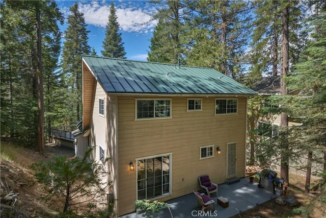 26873 Huron Rd, Lake Arrowhead, CA 92317 - back of property with a patio area, a standing seam roof, and a metal roof