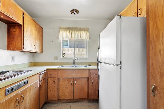 1341 E Monroe, Orange, CA 92867 - kitchen with freestanding refrigerator, light countertops, light tile patterned floors, brown cabinets, and cooktop