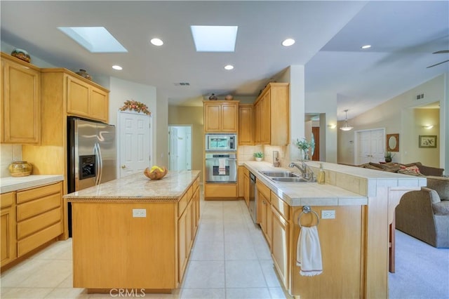 665 Silver Charm Dr, Arroyo Grande, CA 93420 - kitchen featuring appliances with stainless steel finishes, a skylight, a peninsula, light countertops, and recessed lighting