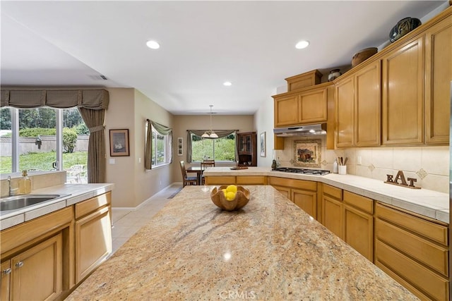 665 Silver Charm Dr, Arroyo Grande, CA 93420 - kitchen with stainless steel gas stovetop, under cabinet range hood, healthy amount of natural light, tasteful backsplash, and recessed lighting