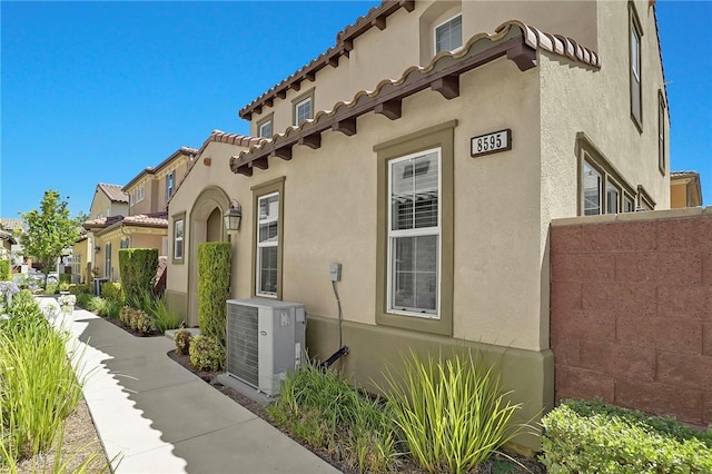 8595 Founders Grove St, Chino, CA 91708 - view of side of property with stucco siding, a tiled roof, and a residential view
