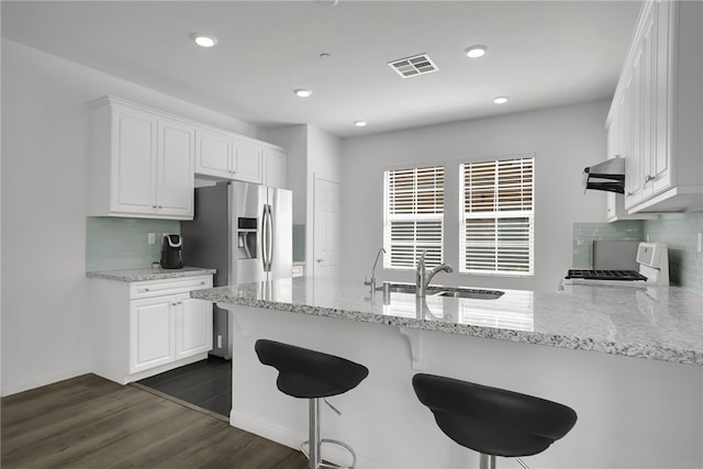 8595 Founders Grove St, Chino, CA 91708 - kitchen with stove, stainless steel fridge with ice dispenser, tasteful backsplash, white cabinetry, and a peninsula
