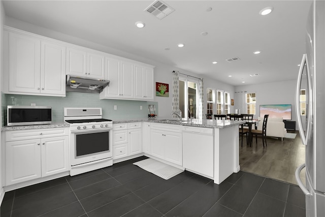 8595 Founders Grove St, Chino, CA 91708 - kitchen with stainless steel appliances, under cabinet range hood, a peninsula, white cabinetry, and backsplash