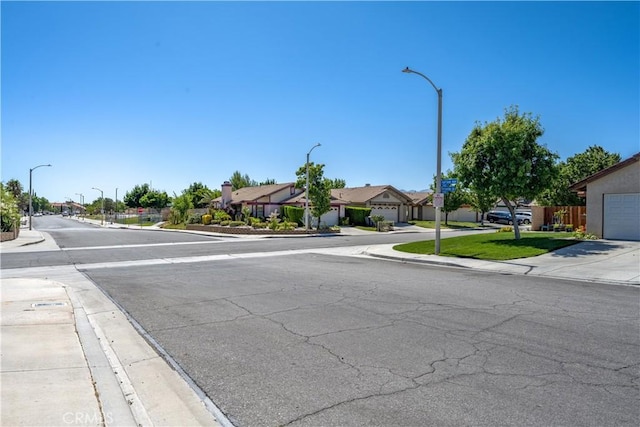 2917 Fairfield Ave, Palmdale, CA 93550 - view of asphalt road featuring sidewalks, street lights, a residential view, and curbs
