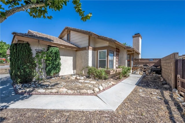 2917 Fairfield Ave, Palmdale, CA 93550 - view of home's exterior featuring stucco siding, a fenced backyard, and a chimney