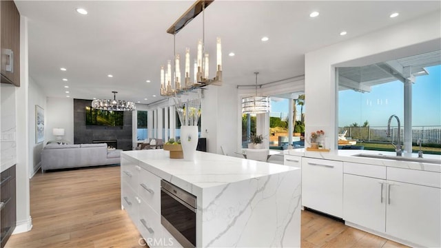 4855 Green Crest Dr, Yorba Linda, CA 92887 - kitchen featuring stainless steel microwave, recessed lighting, a chandelier, a large fireplace, and a center island