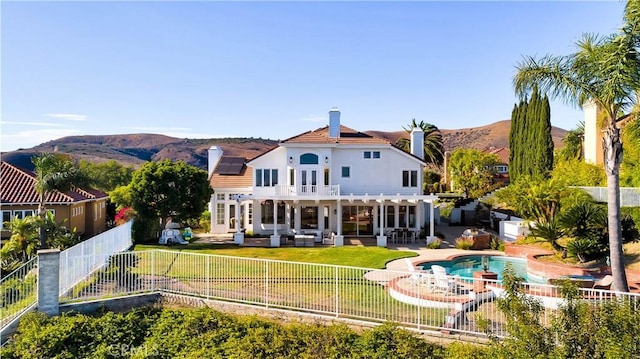 4855 Green Crest Dr, Yorba Linda, CA 92887 - back of house with a fenced backyard, a balcony, a chimney, and a mountain view
