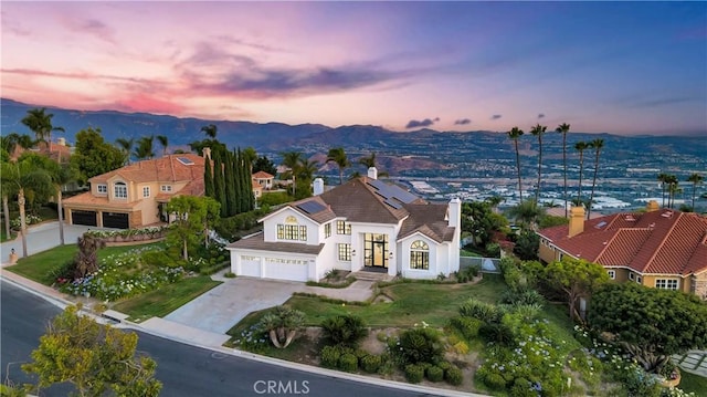 4855 Green Crest Dr, Yorba Linda, CA 92887 - view of front facade featuring french doors, stucco siding, driveway, roof mounted solar panels, and a mountain view