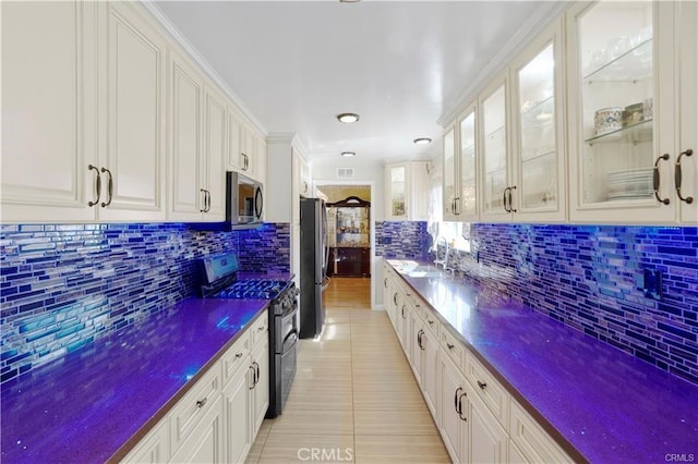 7060 Morse Ave, North Hollywood, CA 91605 - kitchen with stainless steel appliances, dark countertops, tasteful backsplash, and white cabinetry
