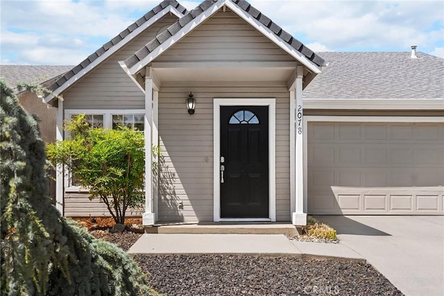 2078 Mansfield Ct, Chico, CA 95928 - view of exterior entry with a garage, driveway, and roof with shingles