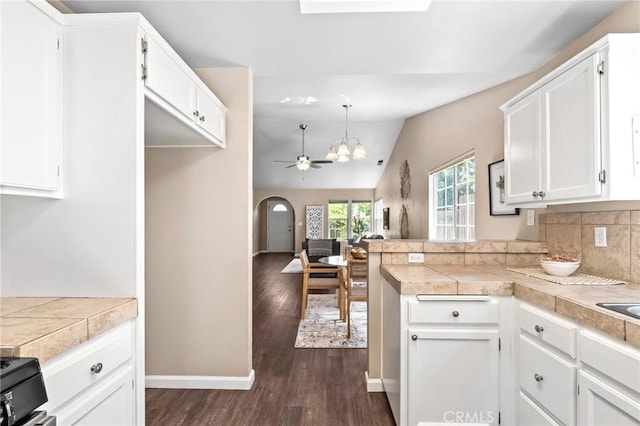 2078 Mansfield Ct, Chico, CA 95928 - kitchen featuring dark wood-style floors, white cabinetry, a ceiling fan, lofted ceiling, and a peninsula