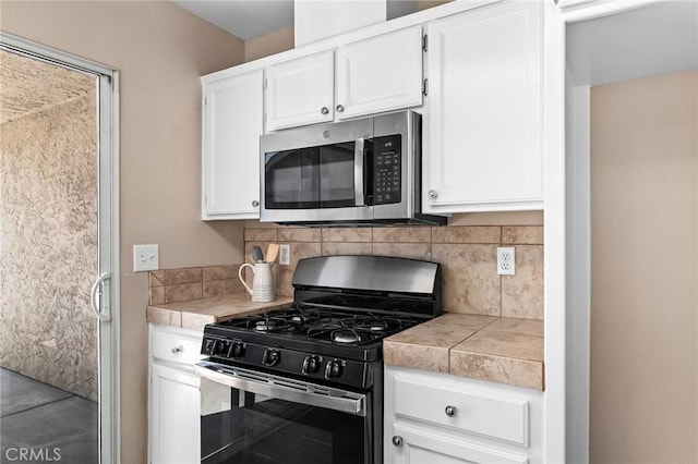 2078 Mansfield Ct, Chico, CA 95928 - kitchen with stainless steel microwave, black range with gas stovetop, white cabinetry, and backsplash