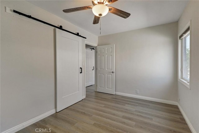108 Chula St, Monrovia, CA 91016 - unfurnished bedroom featuring a barn door, light wood-type flooring, and ceiling fan