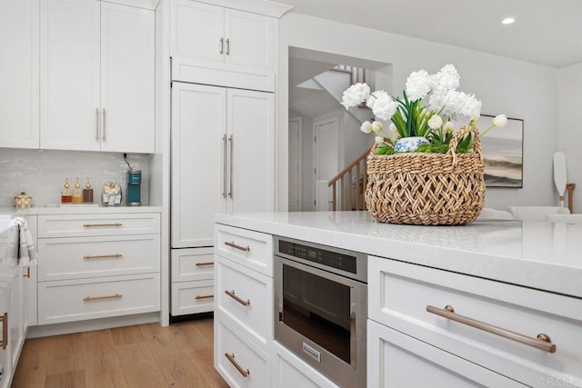 6925 Waters End Dr, Carlsbad, CA 92011 - kitchen with tasteful backsplash, white cabinetry, light wood-style flooring, and recessed lighting