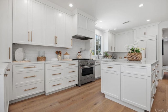 6925 Waters End Dr, Carlsbad, CA 92011 - kitchen with stainless steel range, backsplash, white cabinetry, recessed lighting, and light countertops