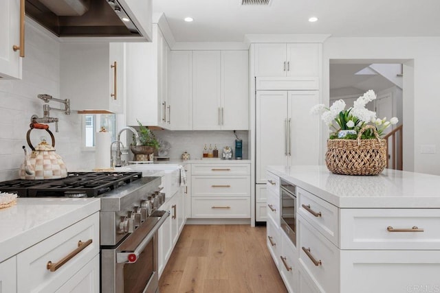 6925 Waters End Dr, Carlsbad, CA 92011 - kitchen with built in appliances, exhaust hood, tasteful backsplash, light wood-type flooring, and white cabinets