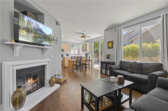 27151 Manor Cir Unit 54, Valencia, CA 91354 - living area with ceiling fan, dark wood-style floors, and a glass covered fireplace