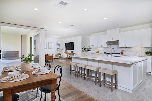 2415 Calle Grandon, Chula Vista, CA 91913 - kitchen featuring under cabinet range hood, backsplash, light countertops, white cabinetry, and recessed lighting