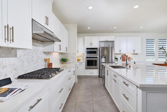 2415 Calle Grandon, Chula Vista, CA 91913 - kitchen featuring under cabinet range hood, stainless steel appliances, white cabinets, tasteful backsplash, and light tile patterned floors