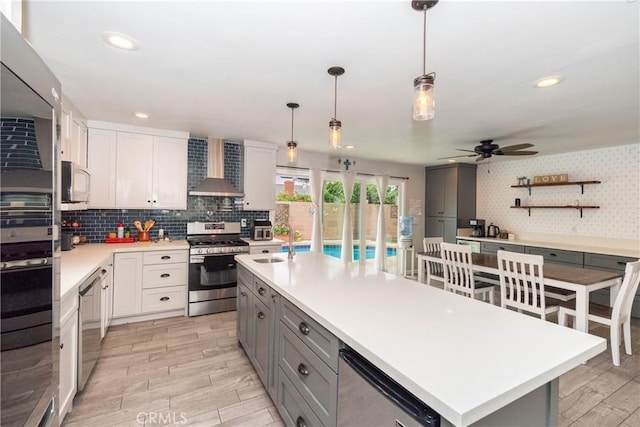 14750 Danbrook Dr, Whittier, CA 90604 - kitchen with stainless steel appliances, light wood-style flooring, gray cabinets, wall chimney exhaust hood, and light countertops