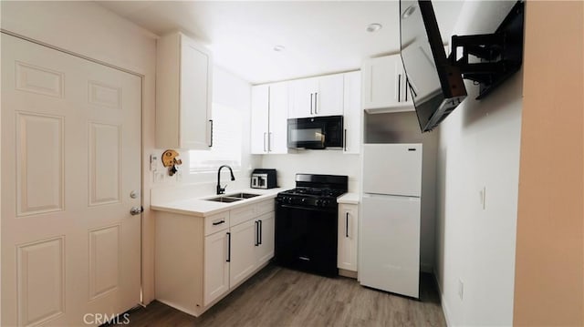 658 W 120th St, Los Angeles, CA 90044 - kitchen featuring black appliances, light wood-style flooring, light countertops, and white cabinetry