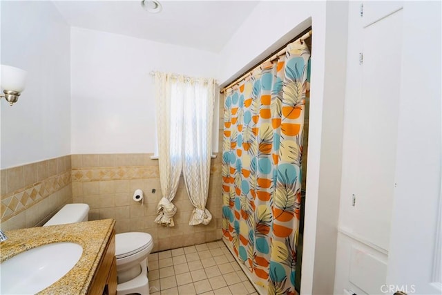 658 W 120th St, Los Angeles, CA 90044 - full bathroom with vanity, tile patterned flooring, tile walls, a shower with curtain, and wainscoting