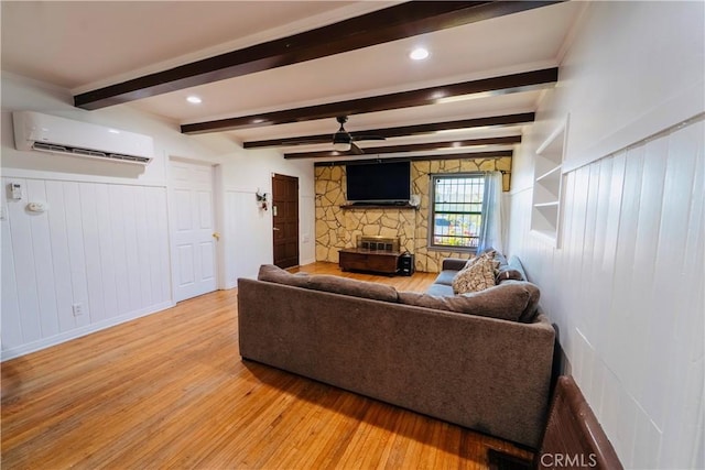 658 W 120th St, Los Angeles, CA 90044 - living area featuring a wall mounted AC, light wood finished floors, a ceiling fan, a fireplace, and beam ceiling