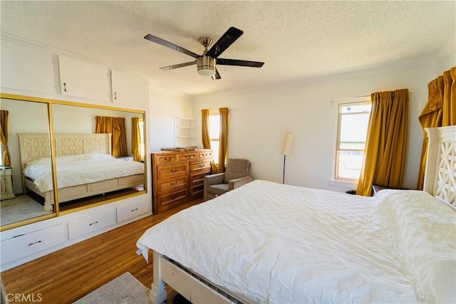 658 W 120th St, Los Angeles, CA 90044 - bedroom featuring wood finished floors, a textured ceiling, a closet, and a ceiling fan