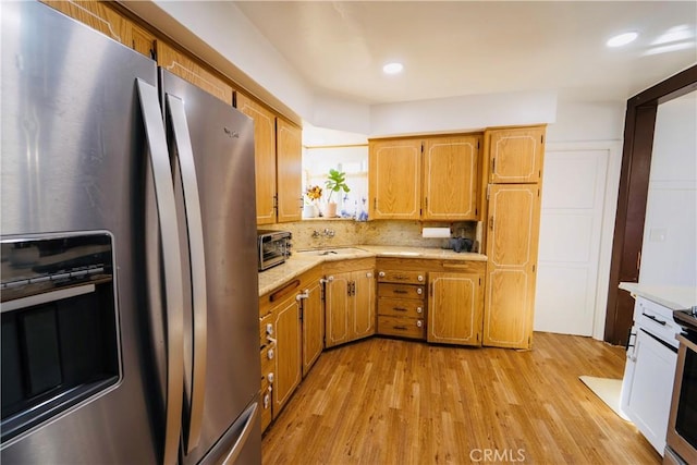 658 W 120th St, Los Angeles, CA 90044 - kitchen featuring stainless steel fridge, light countertops, light wood-style floors, recessed lighting, and brown cabinets