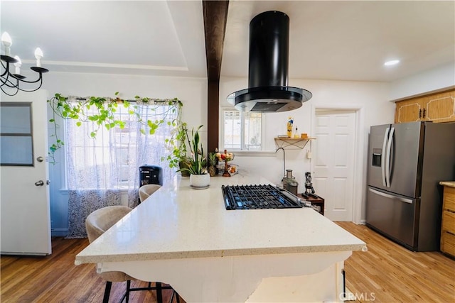 658 W 120th St, Los Angeles, CA 90044 - kitchen featuring stainless steel refrigerator with ice dispenser, island exhaust hood, a kitchen bar, light wood-type flooring, and a peninsula