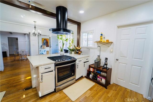 658 W 120th St, Los Angeles, CA 90044 - kitchen with stainless steel range with gas stovetop, range hood, white cabinetry, light countertops, and recessed lighting