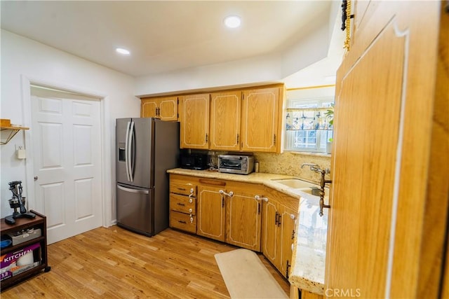 658 W 120th St, Los Angeles, CA 90044 - kitchen with stainless steel fridge, light wood-style flooring, decorative backsplash, brown cabinets, and recessed lighting
