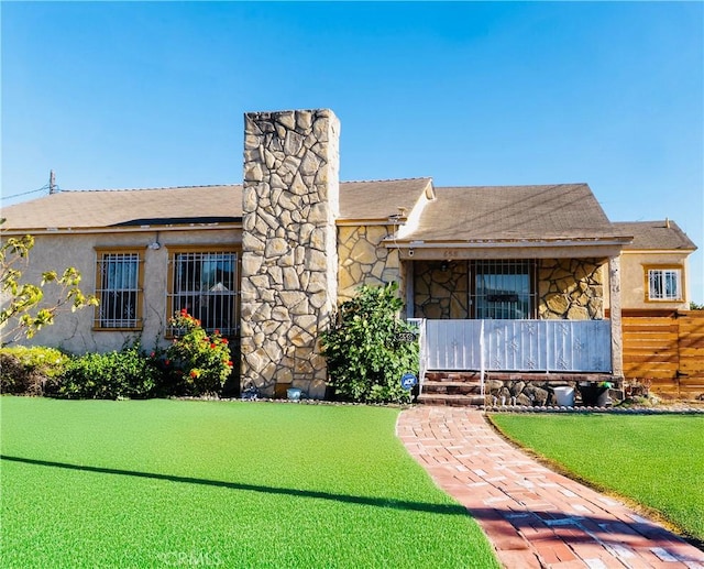 658 W 120th St, Los Angeles, CA 90044 - view of front of home featuring stone siding, stucco siding, a chimney, and covered porch