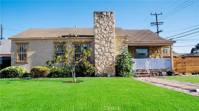 658 W 120th St, Los Angeles, CA 90044 - view of front of property featuring a front lawn, stone siding, stucco siding, a chimney, and roof with shingles