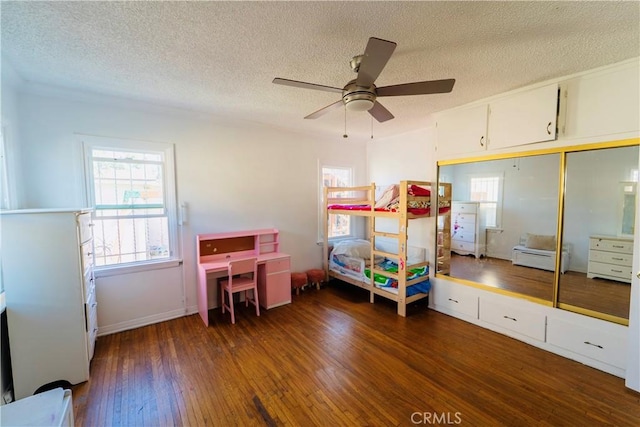 658 W 120th St, Los Angeles, CA 90044 - bedroom with dark wood finished floors, a textured ceiling, multiple windows, a ceiling fan, and a closet