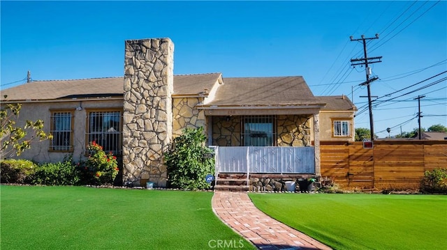 658 W 120th St, Los Angeles, CA 90044 - rear view of house with stone siding, a chimney, a porch, a shingled roof, and stucco siding